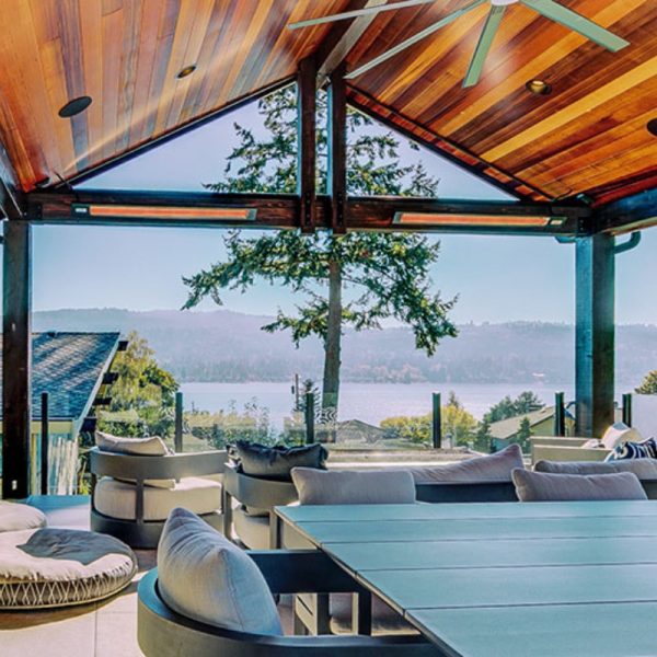 Modern outdoor patio with wooden ceiling, comfortable seating, and scenic lake view. Ideal for relaxation and entertaining.