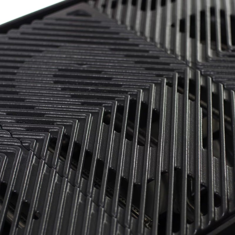 Close-up of a black grilling pan with a textured surface featuring angled grooves, designed for even heat distribution and optimal grilling results.