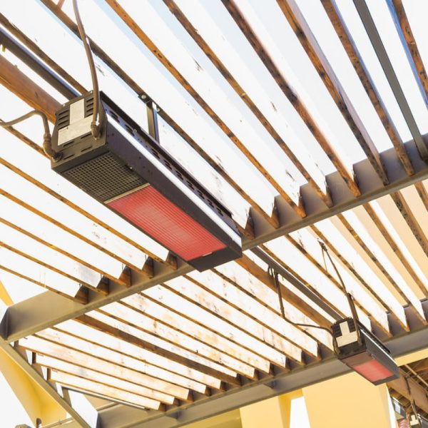 Infrared patio heaters installed under a wooden pergola, providing warmth for outdoor spaces.