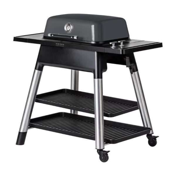 Everdure portable gas grill with a sleek gray design, featuring a cooking surface, side shelves, and two storage racks on a wheeled base for easy mobility.