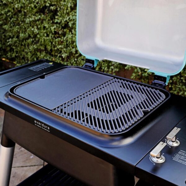 Everdure outdoor grill with a removable cooking surface and lid open, showcasing a sleek design for versatile grilling.