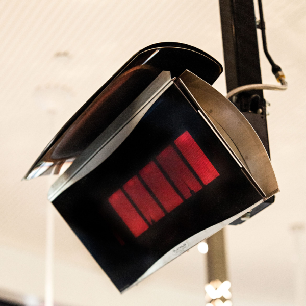 Infrared heating lamp suspended from the ceiling, emitting a warm red glow, ideal for providing heat in various settings.