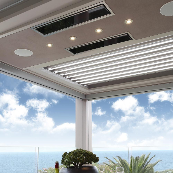 Modern patio ceiling with adjustable slats, recessed lighting, and a scenic ocean view.