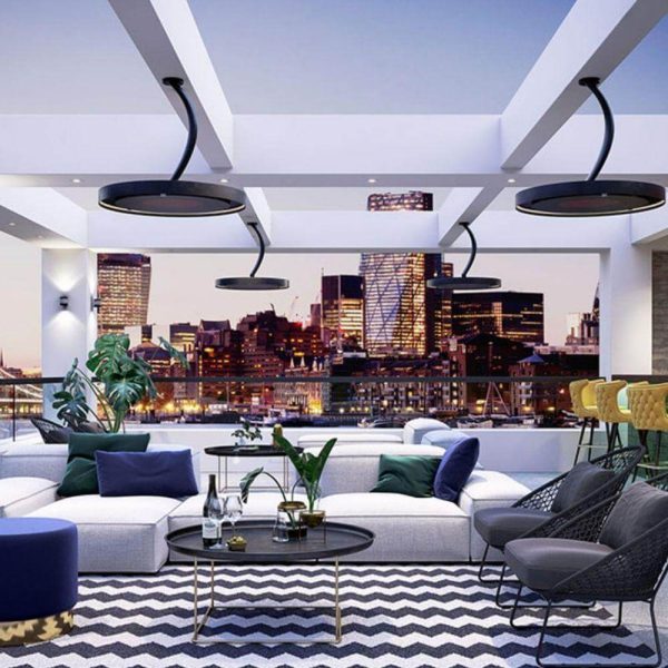Modern living room with city skyline view, featuring stylish furniture, decorative plants, and contemporary lighting.