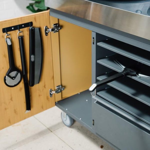 Storage cabinet with hanging kitchen tools and open shelves, featuring a sleek design and a wooden door.