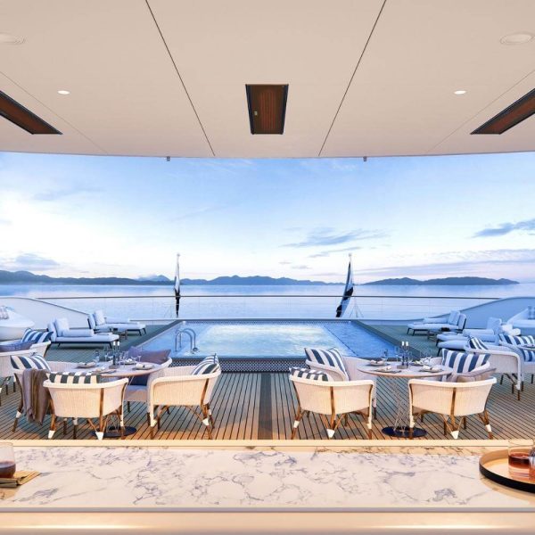 Luxurious yacht deck featuring a swimming pool, stylish lounge chairs, and a scenic ocean view with mountains in the background. Ideal for relaxation and entertainment.