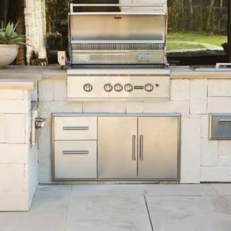 Stainless steel outdoor kitchen with a built-in grill and storage cabinets, featuring a sleek design and modern appliances.