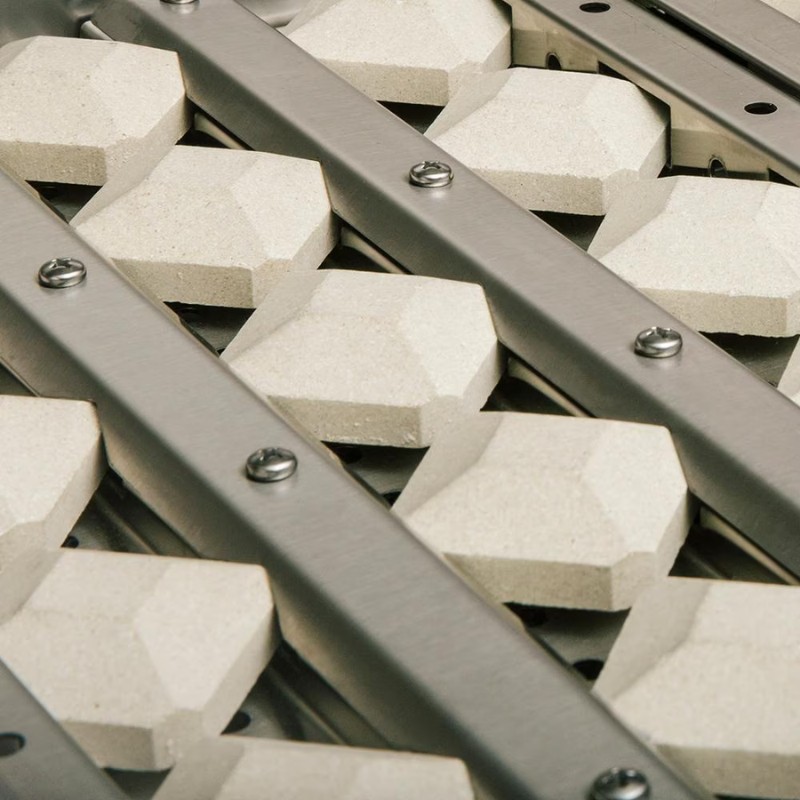 Close-up of a textured surface featuring hexagonal ceramic tiles mounted on a metallic framework, showcasing a modern design suitable for various applications.