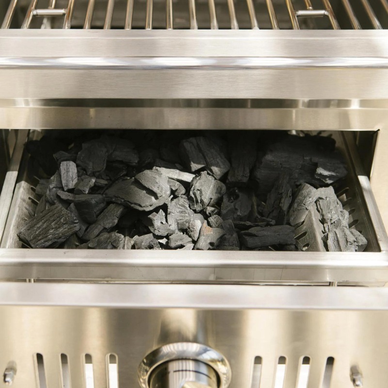 Charcoal briquettes in a stainless steel grill, ready for cooking.