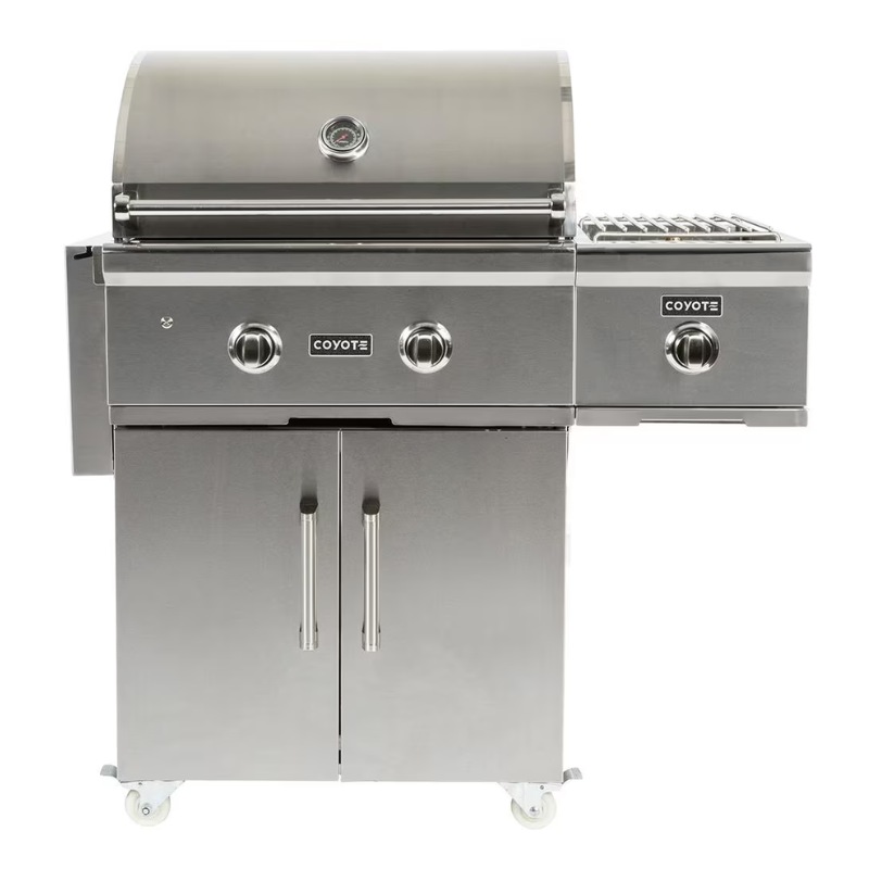 Stainless steel Coyote gas grill with two burners, side shelves, and storage cabinet, ideal for outdoor cooking.