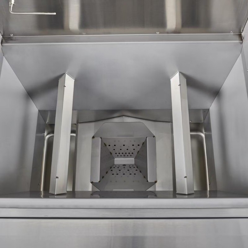 Stainless steel commercial kitchen equipment interior with a funnel-shaped component and drainage holes for efficient food processing.