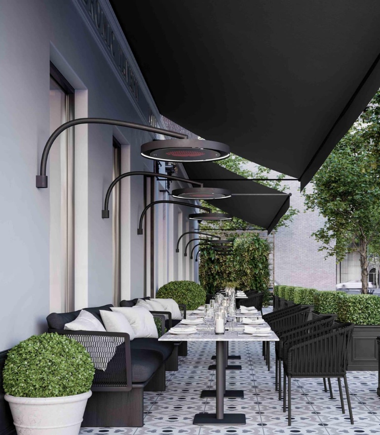 Outdoor dining area featuring modern black furniture, elegant table settings, and stylish overhead heaters under a canopy. Lush greenery enhances the ambiance.