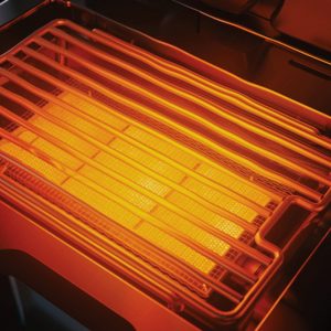 Close-up view of an electric grill heating element glowing orange, showcasing the grill grates and heating surface.