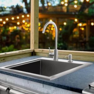Outdoor kitchen sink with modern stainless steel faucet and granite countertop, surrounded by wooden frame and soft lighting in the background.