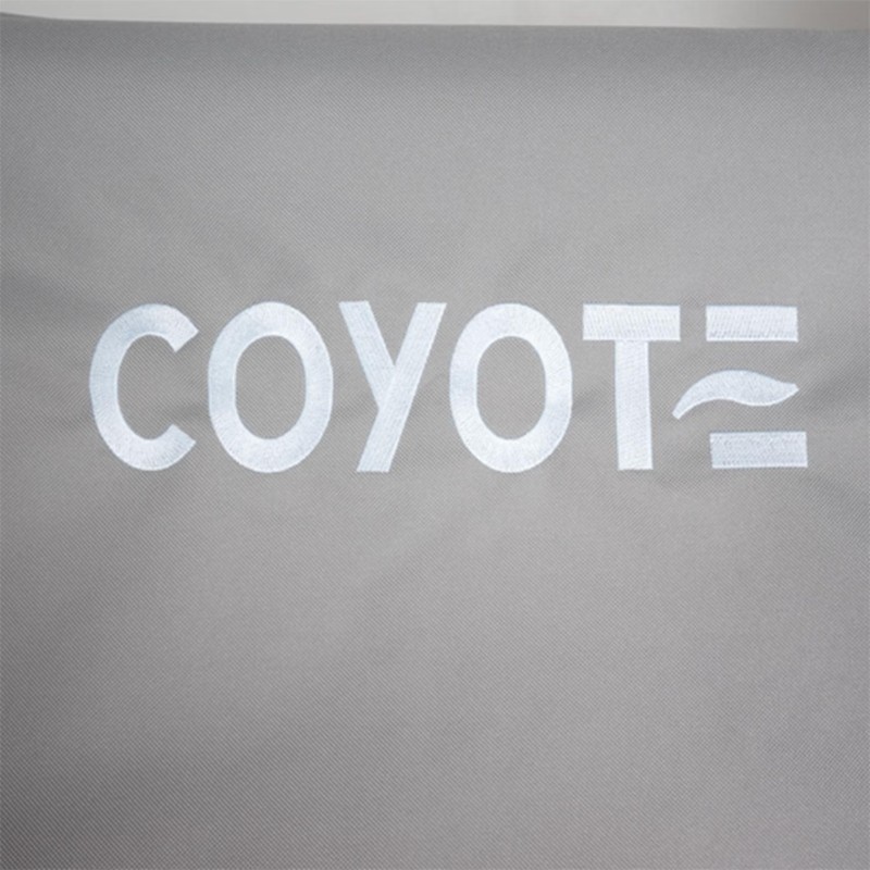 Embroidered "COYOTE" logo on a gray fabric background, showcasing modern design and branding.