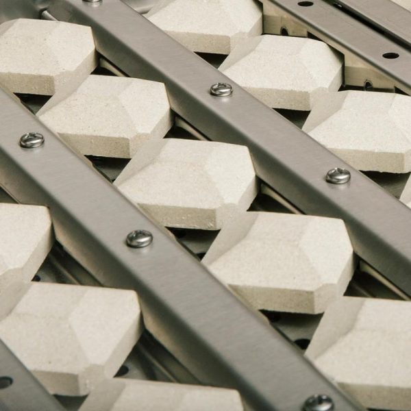 Close-up of a textured surface featuring hexagonal concrete blocks mounted on a metal frame, showcasing an industrial design suitable for flooring or architectural applications.