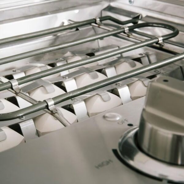 Close-up of a gas stovetop showing burners and control knobs, highlighting stainless steel design and functional features for cooking.