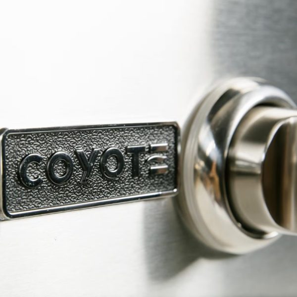 Close-up of a Coyote grill control knob and logo, highlighting premium outdoor cooking equipment.