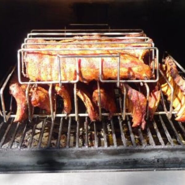 Smoked ribs and pork loin cooking on a barbecue grill, showcasing a delicious, caramelized exterior and smoky flavor.