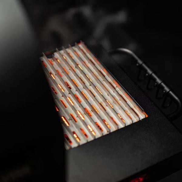 Close-up of a modern electric grill with glowing heating elements, showcasing its sleek design and efficient cooking surface. Ideal for outdoor barbecues and indoor grilling.