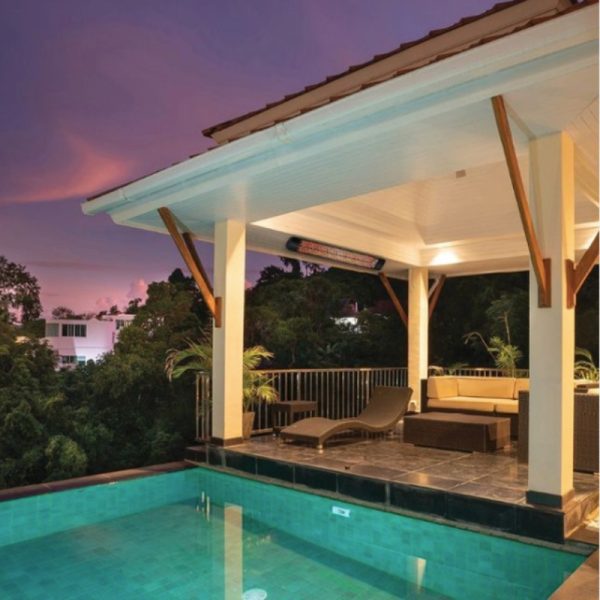 Luxurious outdoor pool area with modern lounge furniture and a stunning sunset backdrop, featuring a covered patio and lush greenery.
