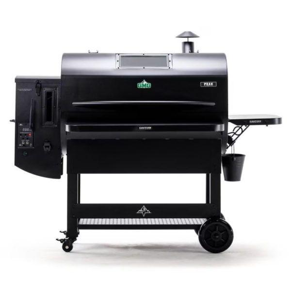 GMG Peak pellet grill with digital controls, side shelf, and storage bucket, designed for efficient outdoor cooking.