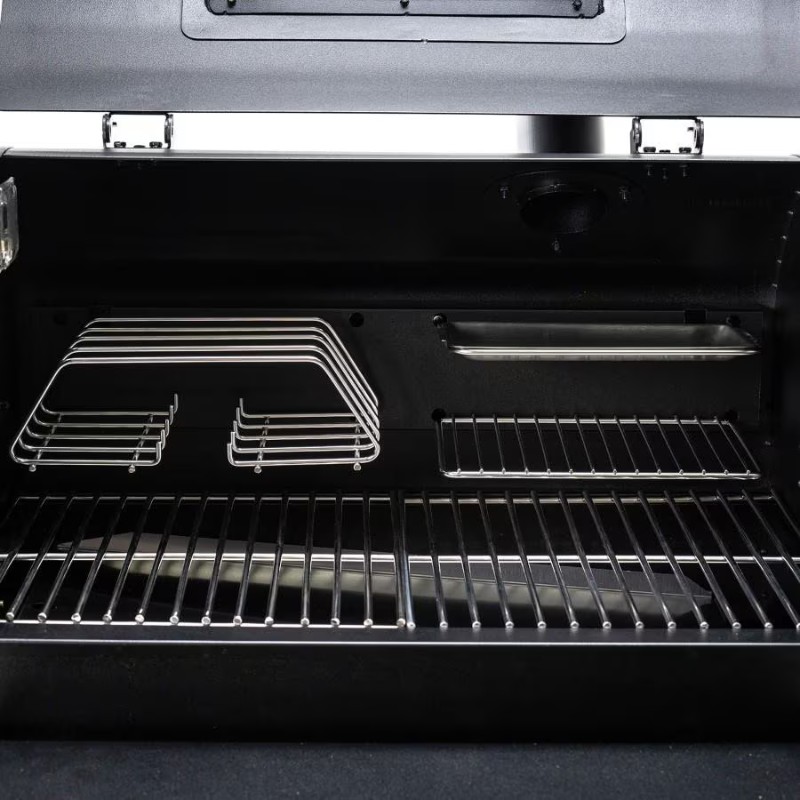 Interior view of a black grill showing stainless steel cooking racks and warming trays, ideal for outdoor barbecuing and grilling.