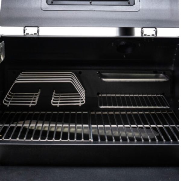 Interior view of a grill showing stainless steel cooking grates and warming racks, designed for efficient heat distribution and easy cleaning.
