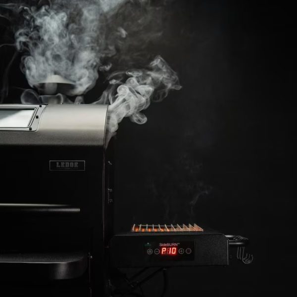 Pellet grill with smoke rising, featuring a digital temperature display on the side.