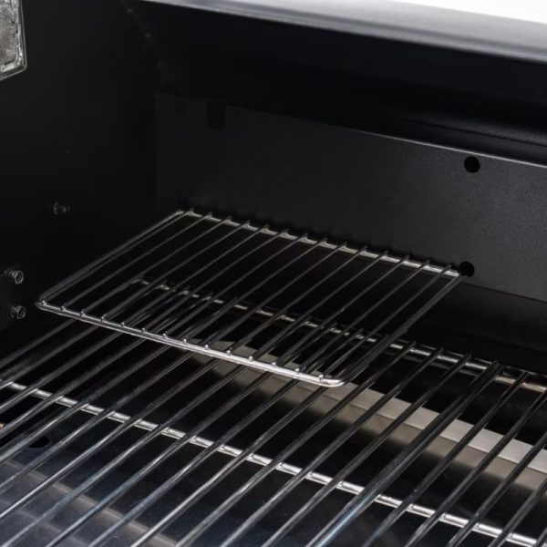 Interior view of a modern grill showcasing a chrome wire cooking rack and a black metal frame. Ideal for outdoor cooking and barbecuing.