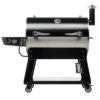 Black and silver pellet grill on wheels with digital control panel and side shelf. Ideal for outdoor cooking and barbecuing.