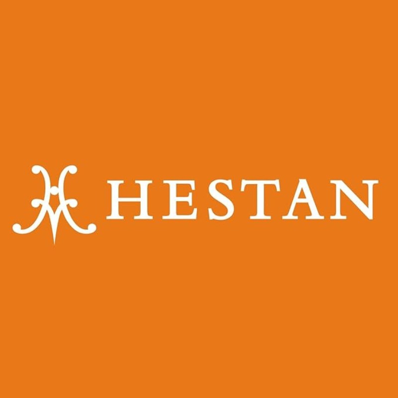 Hestan logo on an orange background, representing premium cookware and kitchen products.