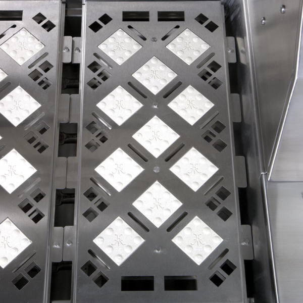 Close-up of a stainless steel grating with a diamond pattern and textured surface, ideal for drainage applications in kitchens or industrial settings.