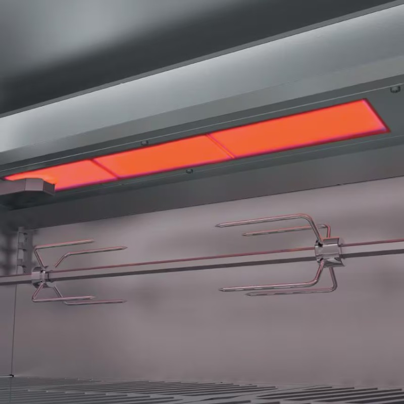 Interior view of a commercial kitchen grill featuring bright red heating elements and stainless steel rotisserie forks for cooking.