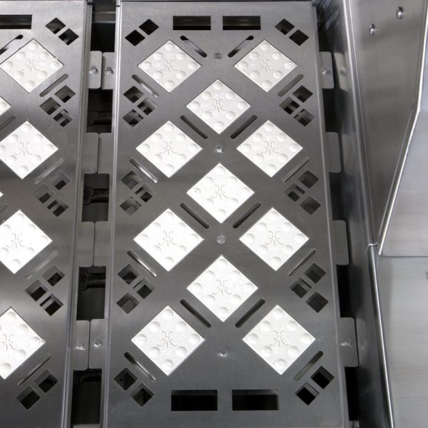 Close-up of a stainless steel surface featuring a patterned design with diamond-shaped, textured tiles, showcasing industrial craftsmanship and durability.