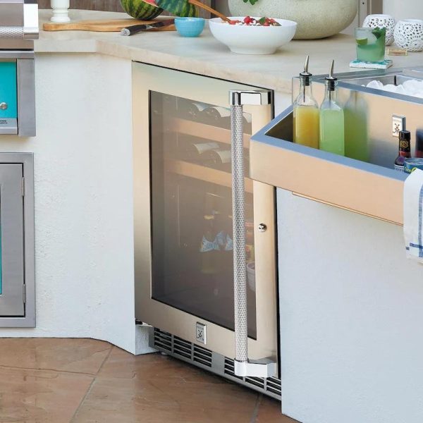 Outdoor kitchen featuring a stainless steel wine cooler with a glass door, adjacent to a beverage station with colorful drinks and ice.