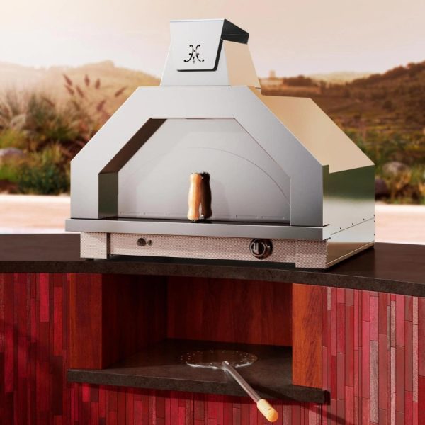 Modern outdoor pizza oven with a sleek stainless steel design, set against a scenic background, featuring a wooden countertop and pizza peel.