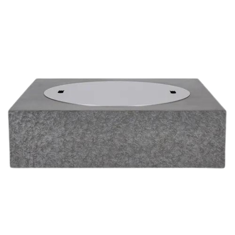 Concrete base with a circular metal cover, designed for outdoor installations or utility access.