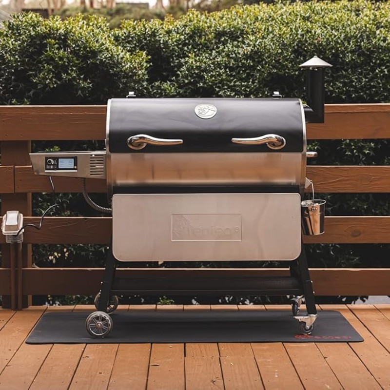Outdoor pellet grill on a wooden deck, featuring a black and stainless steel design, digital control panel, and side shelf for convenient cooking. Ideal for barbecuing and smoking meats.