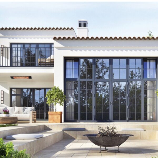 Modern exterior of a stylish home featuring large glass windows, a spacious patio with seating, and a decorative fire pit surrounded by greenery.