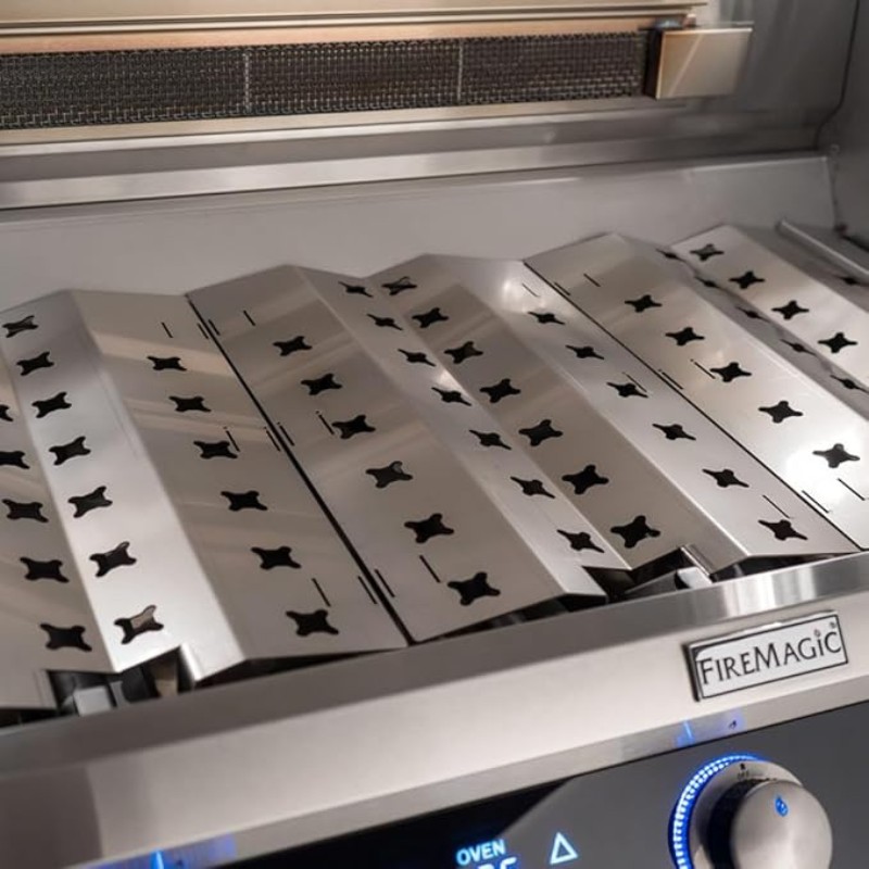 Stainless steel grill grates with decorative cutouts on a Fire Magic gas grill, showcasing high-quality craftsmanship and cooking surface.