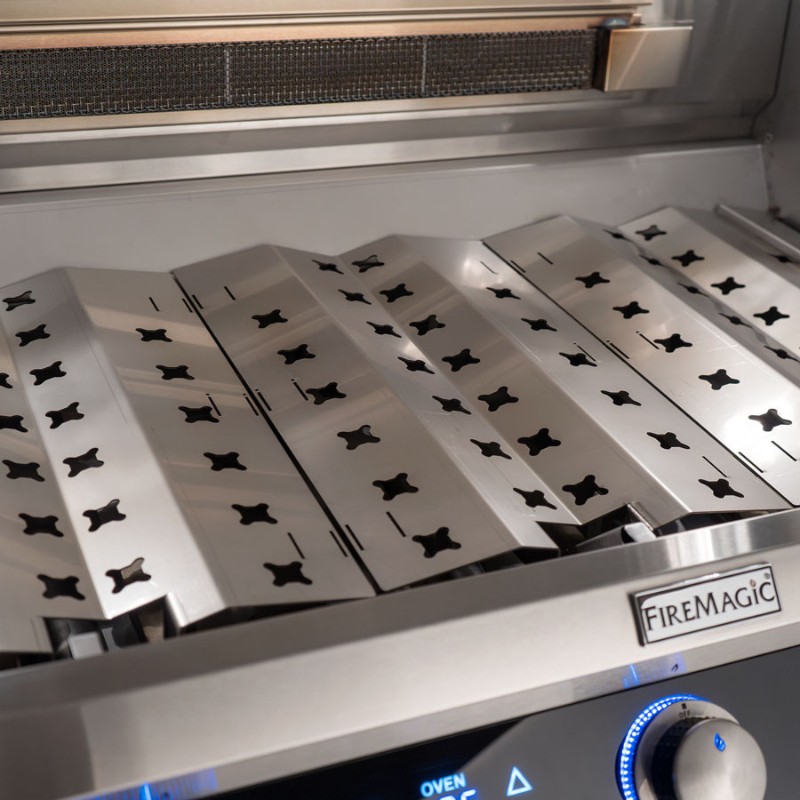 Stainless steel grill grates of a Fire Magic gas grill, showcasing a sleek design with ventilation holes for optimal heat distribution.