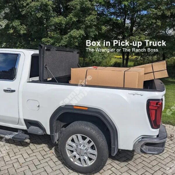 White pickup truck with a closed bed cover and cardboard boxes inside, parked on a paved surface. Green trees in the background.