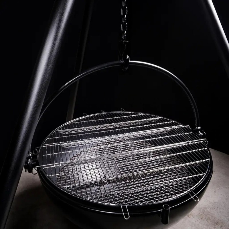 Hanging charcoal grill with a circular metal grate, suspended by a chain, set against a dark background.