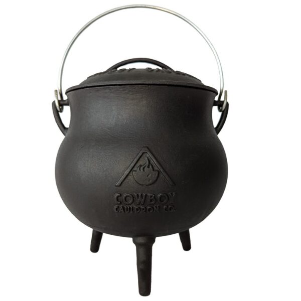 Cast iron cauldron with a metal handle and three supports, featuring the "Cowboy Cauldron Co." logo. Ideal for outdoor cooking and camping.