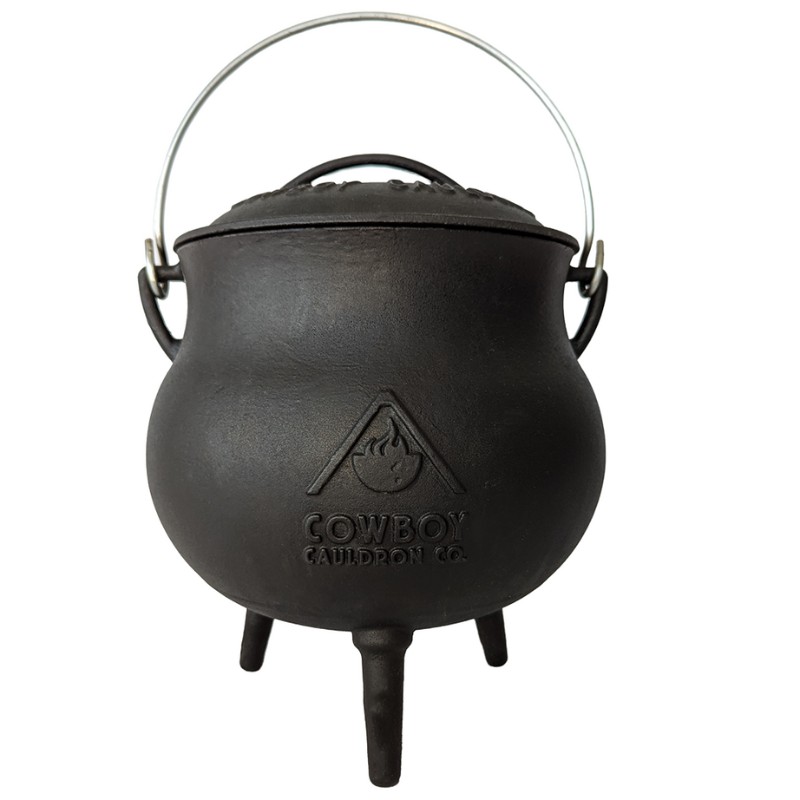 Cast iron cauldron with a metal handle and three supports, featuring the "Cowboy Cauldron Co." logo. Ideal for outdoor cooking and camping.