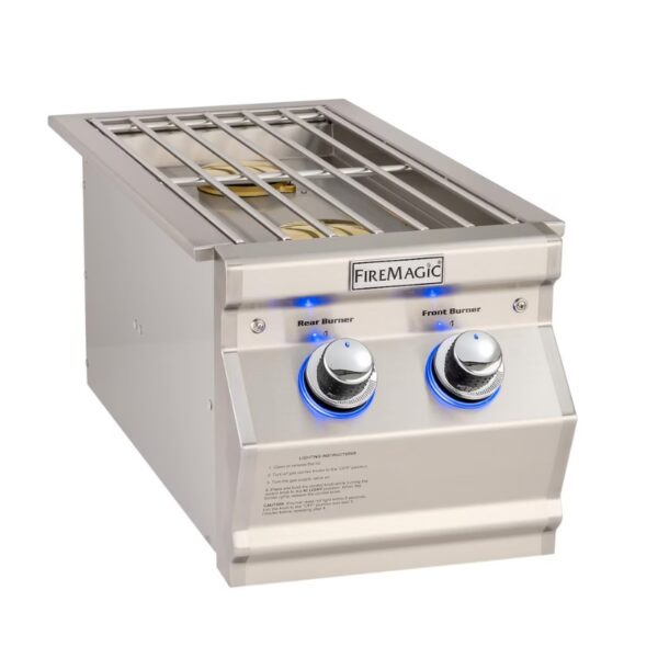 Stainless steel Fire Magic built-in grill with front and rear burners, featuring illuminated control knobs and a cooking grate.