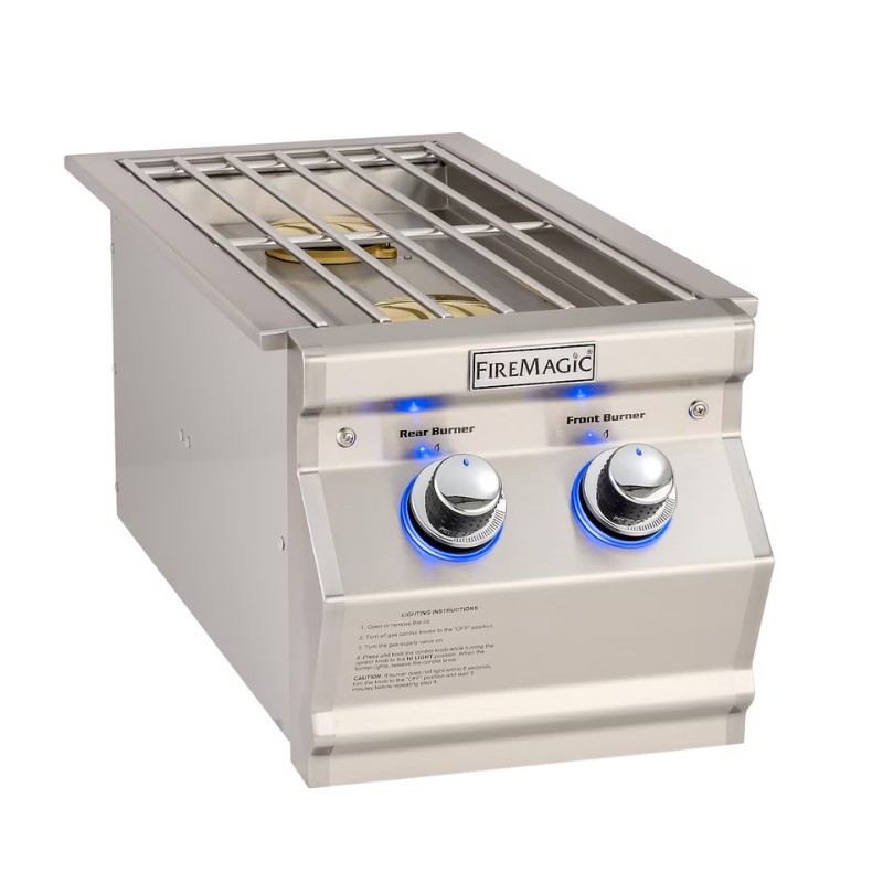 Stainless steel Fire Magic built-in gas grill with dual burners and illuminated control knobs, designed for outdoor cooking.