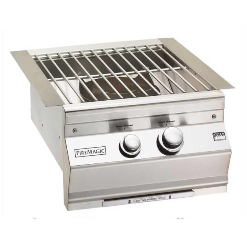 Stainless steel Fire Magic built-in gas grill with two control knobs and a slotted cooking grate.