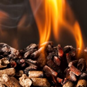 Close-up of glowing embers and flame, highlighting burning wood pellets for heating or cooking.